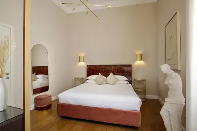 a bedroom with a white bed and a mirror at Daplace - Santa Susanna Suites in Rome