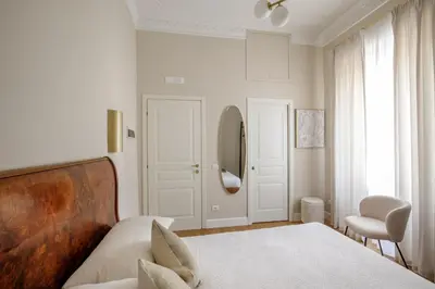 a bedroom with a bed and a chair and a mirror at Daplace - Santa Susanna Suites in Rome