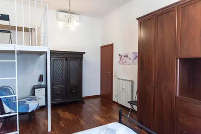 a room with a wooden cabinet and a bedroom at A due passi dal Vaticano in Rome