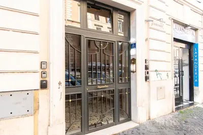 a store front with black glass doors on a building at A due passi dal Vaticano in Rome