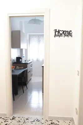 a kitchen with a door open to a kitchen with a table at Appartamento Hector in Rome
