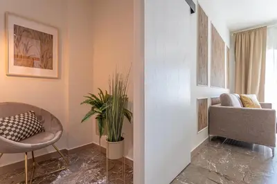 a living room with a chair and a plant at CORNELIA COZY&ELEGANCE FLAT in Rome