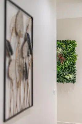 a picture hanging on a wall with a plant at CORNELIA COZY&ELEGANCE FLAT in Rome