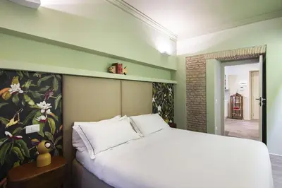 a bedroom with a white bed with a flower mural at Luxury Fori Imperiali Apartment in Rome
