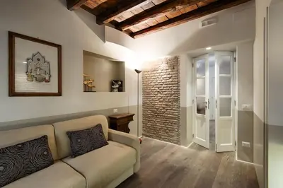 a living room with a couch and a brick wall at Luxury Fori Imperiali Apartment in Rome