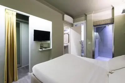 a bedroom with a white bed and a tv at Luxury Fori Imperiali Apartment in Rome