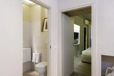 a bathroom with a toilet and a television in a room at Luxury Fori Imperiali Apartment in Rome