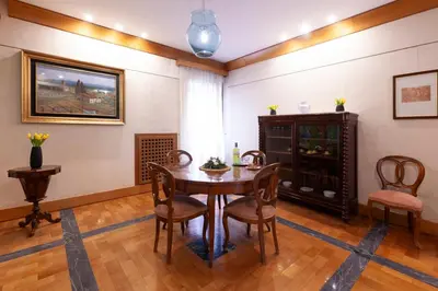 a dining room with a wooden table and chairs at Harry's Bar Trevi Luxury Apartments - Sardegna in Rome