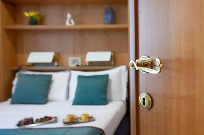 a room with a bed with blue pillows and a door at Harry's Bar Trevi Luxury Apartments - Sardegna in Rome