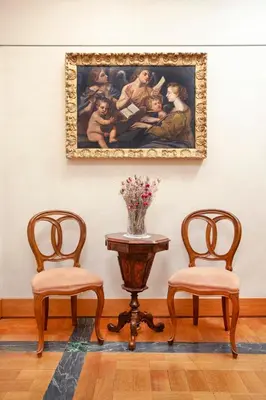 two chairs and a table with a painting on the wall at Harry's Bar Trevi Luxury Apartments - Sardegna in Rome