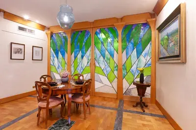 a dining room with a table and a large stained glass window at Harry's Bar Trevi Luxury Apartments - Sardegna in Rome