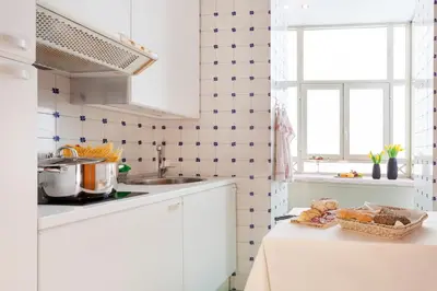 a kitchen with white cabinets and a counter with food on it at Harry's Bar Trevi Luxury Apartments - Sardegna in Rome
