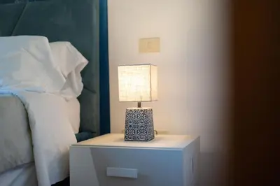 a lamp on a night stand next to a bed at Pellegrino Apartments in Rome