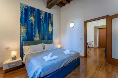 a bedroom with a bed with a painting on the wall at Pellegrino Apartments in Rome