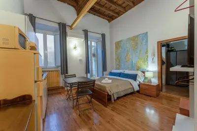 a bedroom with a bed and a table and a desk at Pellegrino Apartments in Rome