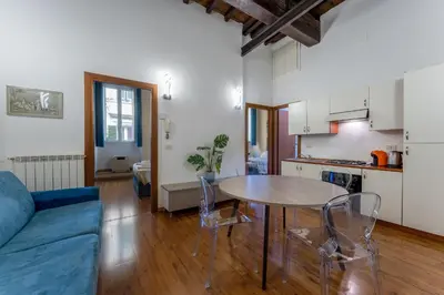 a living room with a table and a kitchen at Pellegrino Apartments in Rome