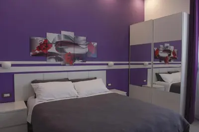 a purple bedroom with a bed and a mirror at Apartment Nido di Roma Suite, Jacuzzi King Size, Metro C in Rome