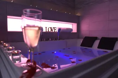 a room with a table with a glass of wine at Apartment Nido di Roma Suite, Jacuzzi King Size, Metro C in Rome