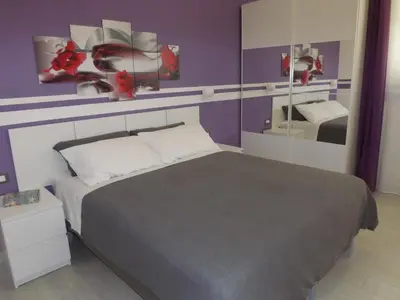 a bedroom with a bed with purple walls and a mirror at Apartment Nido di Roma Suite, Jacuzzi King Size, Metro C in Rome