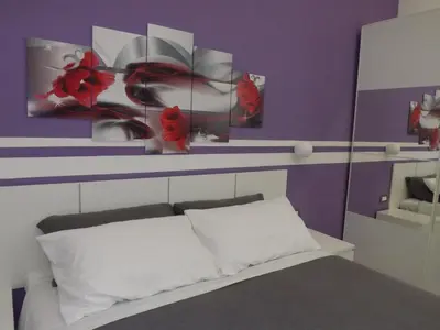 a bedroom with purple walls and a white bed with red flowers at Apartment Nido di Roma Suite, Jacuzzi King Size, Metro C in Rome