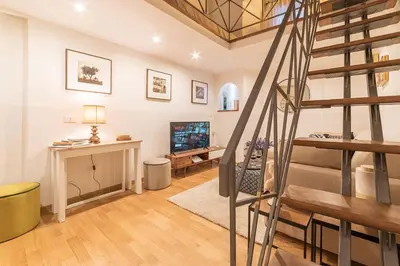 a living room with a staircase and a television at Campo De' Fiori 35 (Centro di Roma/Appartamento accogliente) - FromhometoRome in Rome