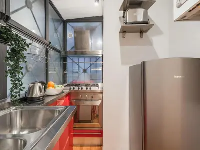 a kitchen with red cabinets and a stainless steel refrigerator at The Best Rent - Spacious two-bedroom apartment in old town in Rome