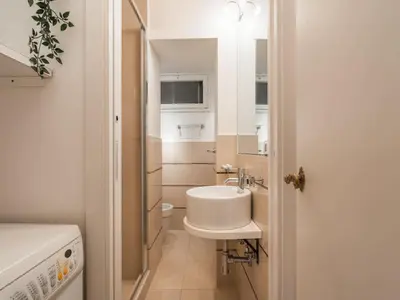 a white bathroom with a sink and a mirror at The Best Rent - Spacious two-bedroom apartment in old town in Rome