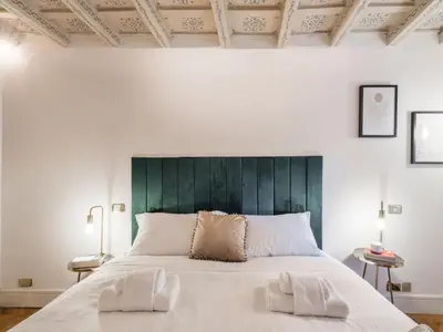 a bedroom with a large bed with a green headboard at The Best Rent - Spacious two-bedroom apartment in old town in Rome
