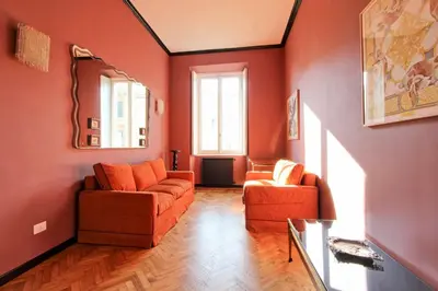 a living room with orange furniture and a mirror at Tibullo ,Classico ed Elegante Appartamento in Rome
