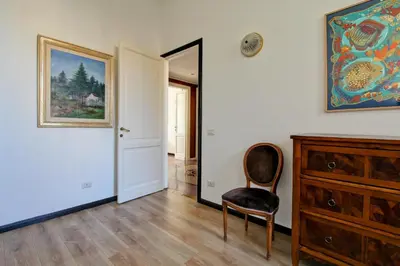 a room with a chair and a painting on the wall at Tibullo ,Classico ed Elegante Appartamento in Rome