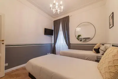 a hotel room with two beds and a mirror at Toscana 6 - FromhometoRome in Rome