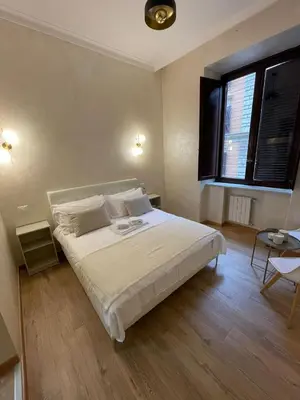 a bedroom with a large white bed with a window at Ten Miles Guesthouse Roma in Rome