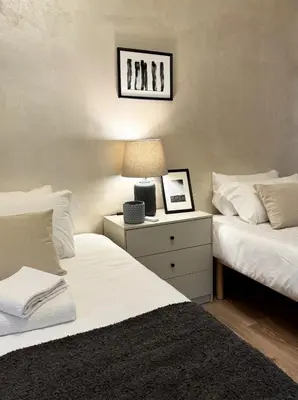 a bedroom with two beds and a lamp on a night stand at Ten Miles Guesthouse Roma in Rome