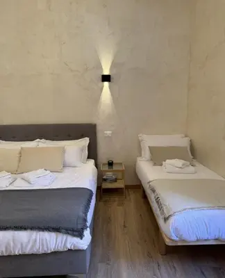 two beds sitting next to each other in a room at Ten Miles Guesthouse Roma in Rome