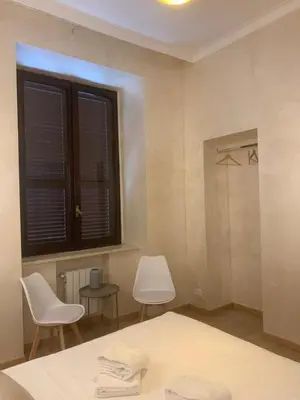 a bedroom with a shower and a bed and two chairs at Ten Miles Guesthouse Roma in Rome