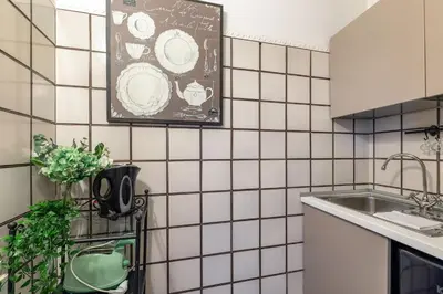a kitchen with white tiled walls and a sink at Rome As You Feel - Santo Stefano in Rome