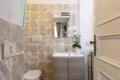 a bathroom with a sink and a stone wall at Rome As You Feel - Santo Stefano in Rome