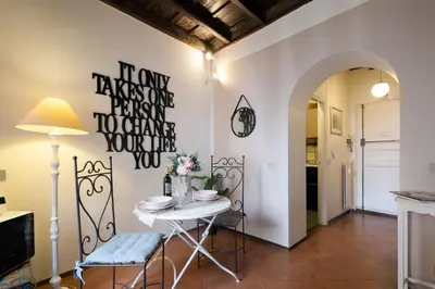 a dining room with a table and a sign on the wall at Rome As You Feel - Santo Stefano in Rome
