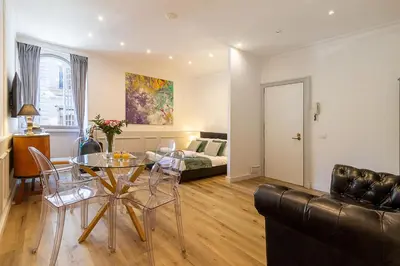 a living room with a leather couch and a table at Crispi 30 Stylish Apartment in Rome