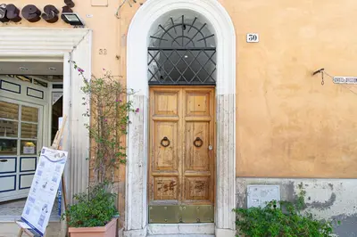 a glass table with a vase of flowers and a bowl of fruit at Crispi 30 Stylish Apartment in Rome