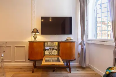 a living room with a glass table and a leather chair at Crispi 30 Stylish Apartment in Rome
