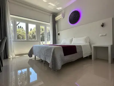 a bedroom with a bed with a purple light on the wall at St.Peter's Moon in Rome