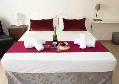 a bed with a bottle of wine and a plate of food at ArtHouse Termini in Rome