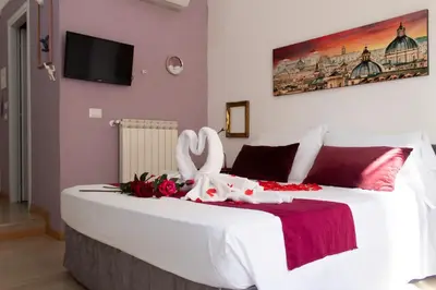 a white bed with flowers and swans on it at ArtHouse Termini in Rome