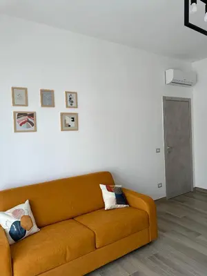 a living room with a brown couch against a white wall at Casa Giorgia a 4 fermate metro dal Vaticano in Rome