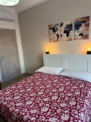 a bedroom with a bed with a red and white blanket at Casa Giorgia a 4 fermate metro dal Vaticano in Rome