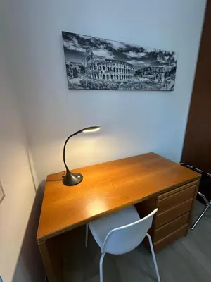 a wooden desk with a lamp and a white chair at Casa Giorgia a 4 fermate metro dal Vaticano in Rome