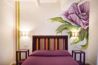 a bedroom with a bed with a flower mural on the wall at Famo Pace apartments in Rome