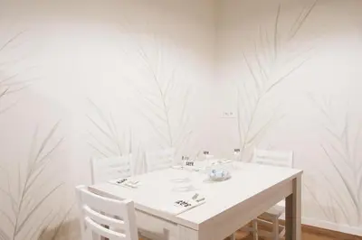 a white dining room with a white table and chairs at Famo Pace apartments in Rome