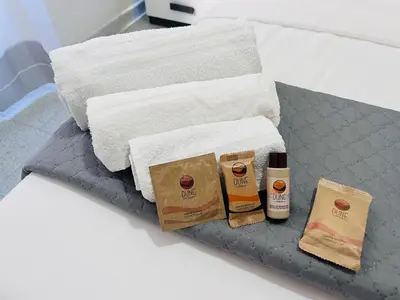 two towels and two bottles of coffee on a bed at Apartment Colli [3m metro] in Rome